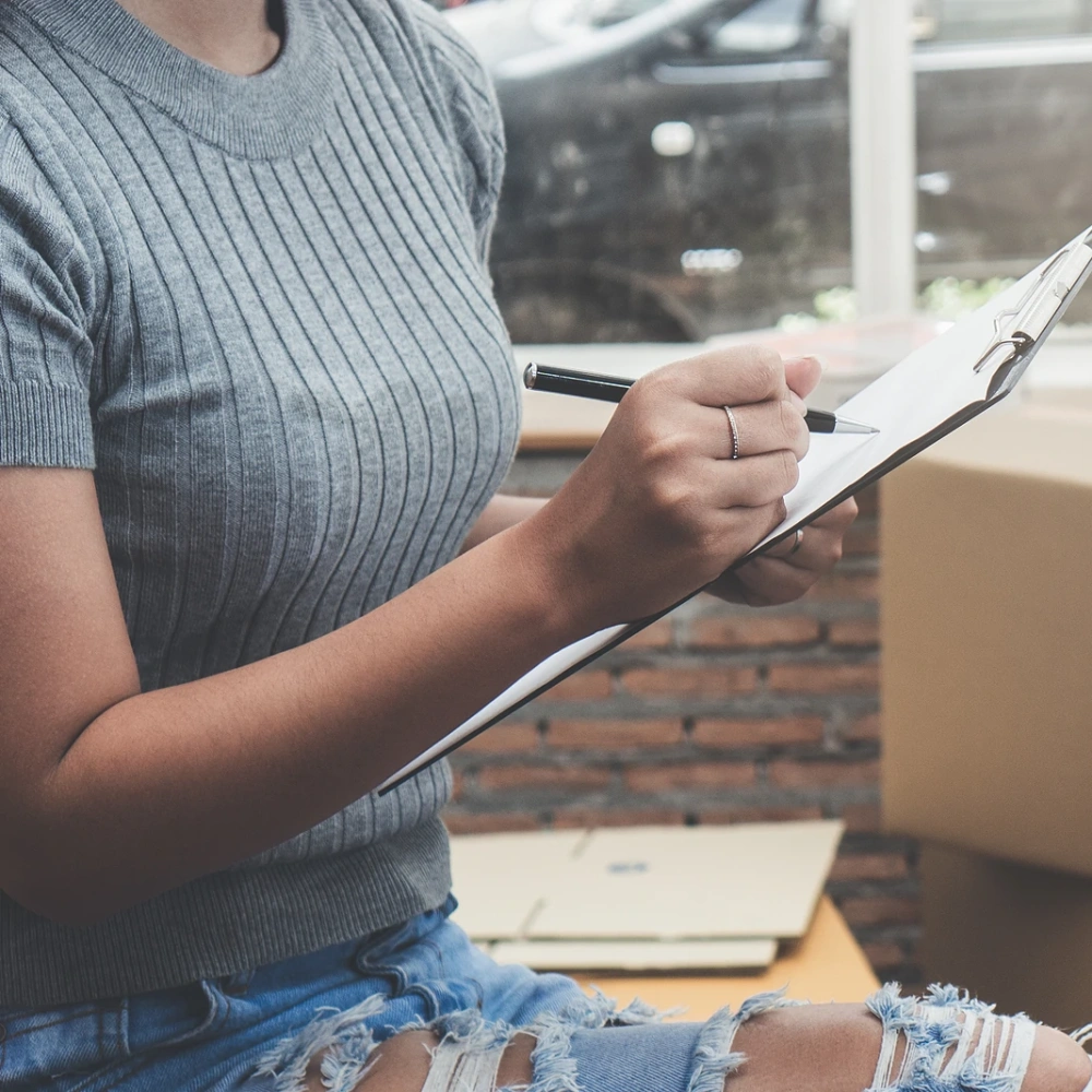 Woman writing on clipboard