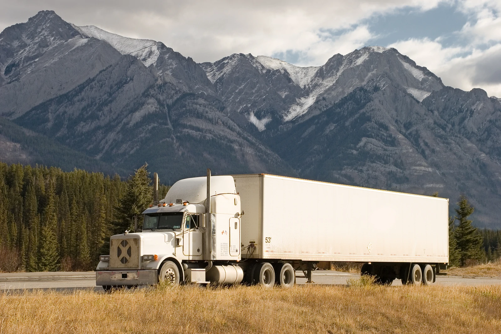 Semi-truck on a road in front of mountains